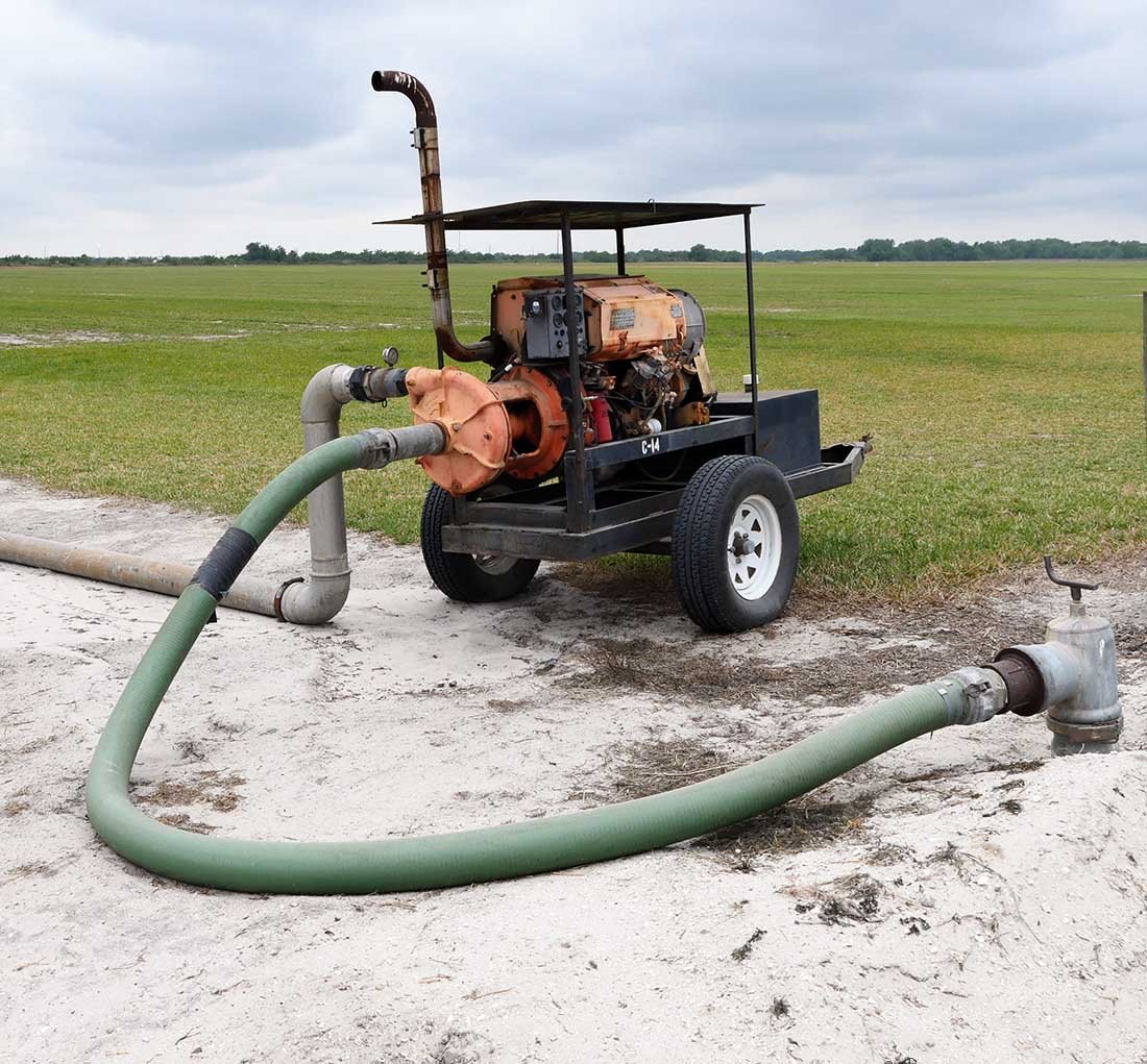 Mobile irrigation pump on trailer, attached to aluminum pipe on sod farm.